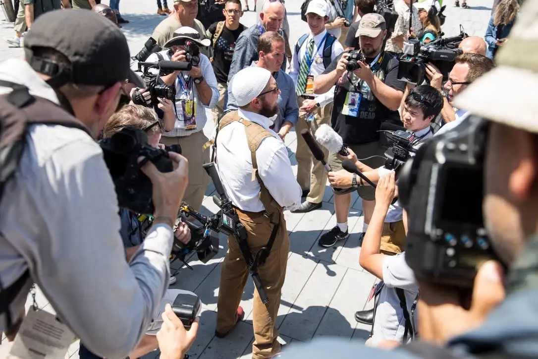 Dr. Micah Naziri speaking with press during a public community-defense presence